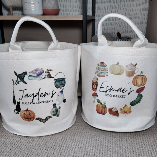 Two white bags with Halloween-themed designs and text on a neutral background.